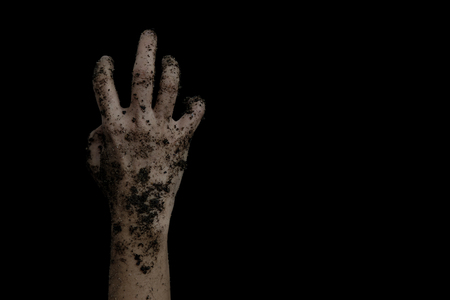The hands of the zombies emerge from the grave isolated on black background.の写真素材