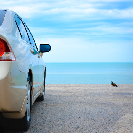 Golden car parked at the blue sea.の写真素材