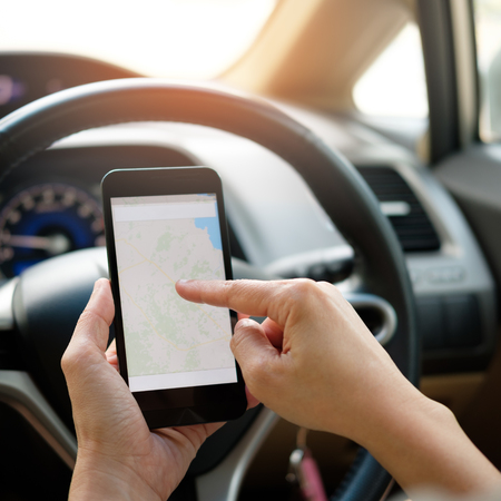 Hand is holding a touch phone in the car.の写真素材