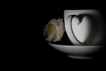 Hot coffee in white ceramic cup with shiny heart shadow, with copy space to write. Valentine concept.の写真素材