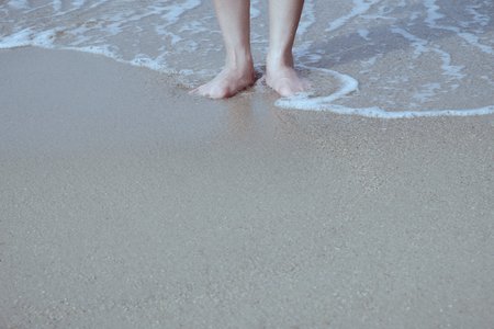 Feet to soak in the sea water with copy space to write.