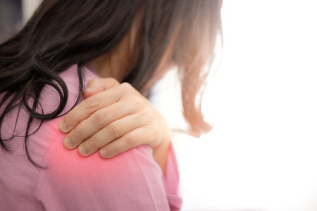 Asian woman in pink cloth having Shoulder pain, concept of health care.の写真素材