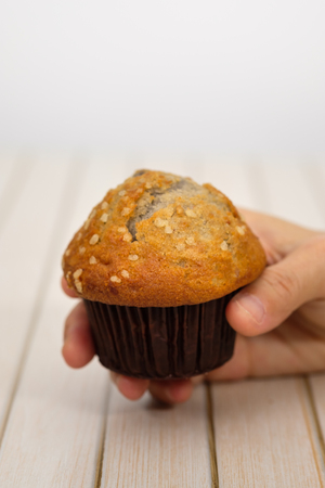 Hands holding a blueberry muffin look delicious. Select focus. Vertical picture.の写真素材