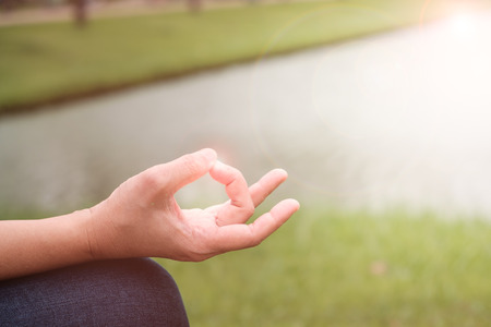 Closeup of woman's hands meditating in the garden.の写真素材