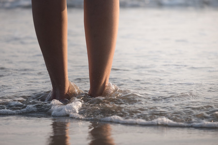 Close up of female legs walking by the beach.の写真素材