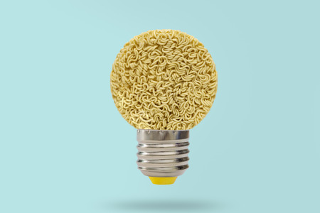 Idea picture-Nests of dried noodles with lamp on blue background.