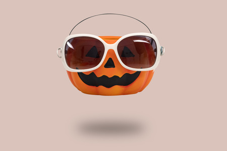 Halloween pumpkin with glasses on pink background. Halloween minimal idea concept.の写真素材