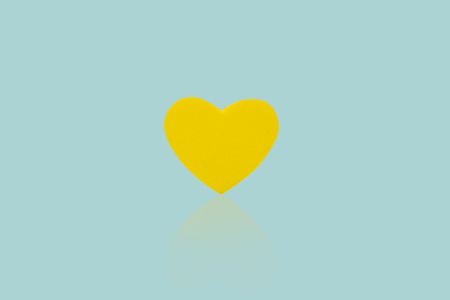 Yellow heart isolated on blue background.の写真素材