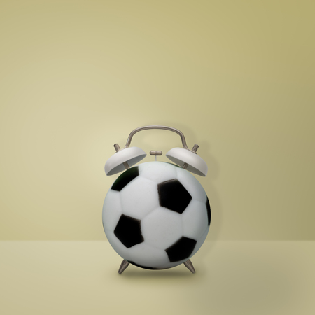 Football alarm clock on pastel yellow background, Creative idea minimal style, time concept.の写真素材