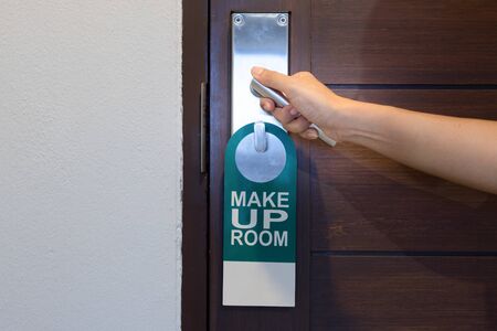 hand holding the door knob with label on a door handle -make up room in Hotel.の写真素材