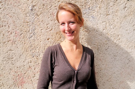 Outdoor portrait young woman with brick wallの写真素材