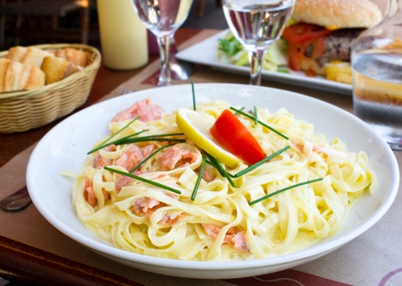 plate of pasta and smoked salmon with tomatoの写真素材