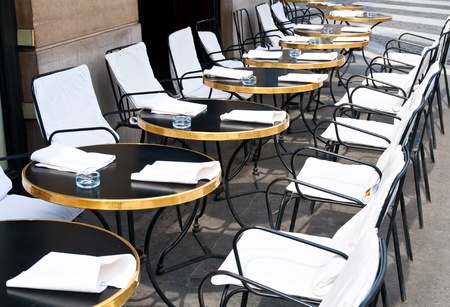 Street view of a Cafe terrace with empty tables and chairs