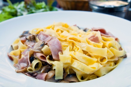 tasty pasta with roast ham on the tableの写真素材