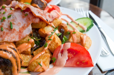 meatball, bacon and potatoes with lettuce on white platの写真素材