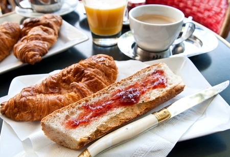 Breakfast with coffee and croissants in a basket on table