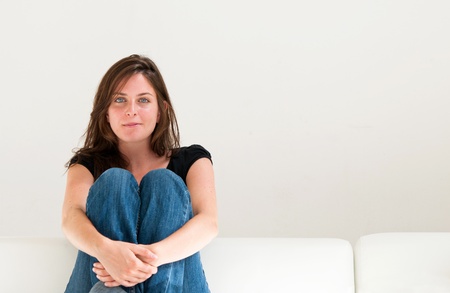 beautiful young woman on the couch in the living roomの写真素材