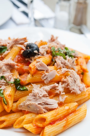 close-up of plate of pasta and smoked salmon with tomatoの写真素材