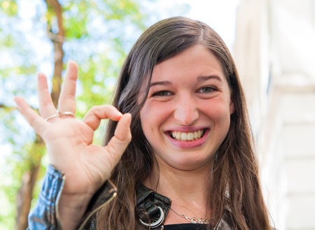 beautiful young attractive woman outdoors portrait with OKの写真素材