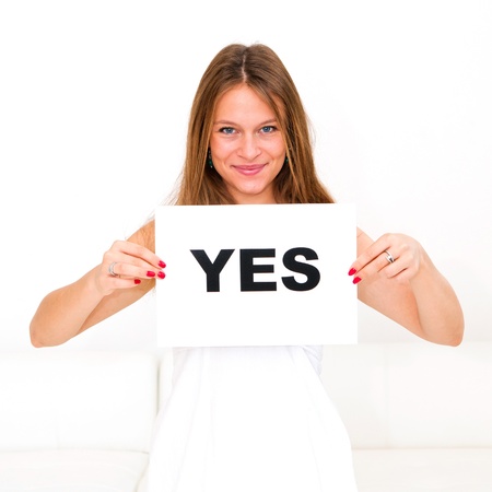 happy portrait young woman with board yesの写真素材