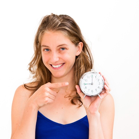 beautiful young woman holding alarm clock