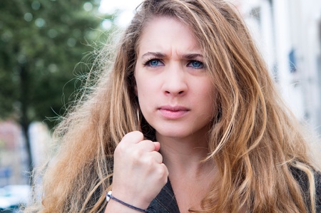 portrait of young attractive woman enjoying success with clenched fists in streetの写真素材