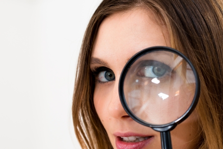 woman with magnifying glass on a white backgroundの写真素材