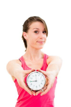 young beautiful woman holding a clock on a white backgroundの写真素材