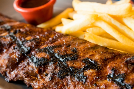 Grilled steak - Grilled meat ribs on the plate with hot sauce