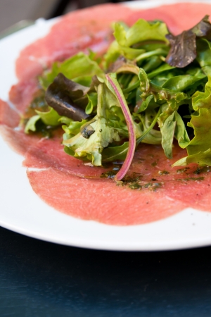 Fresh Sliced raw beef meat with leaf lettuce on tableの写真素材