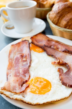 Breakfast with coffee and croissants in a basket on tableの写真素材