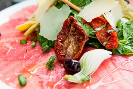 Fresh Sliced raw beef meat with leaf lettuce on tableの写真素材