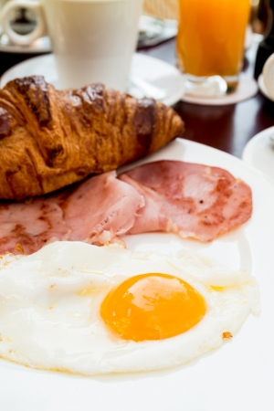 Breakfast with coffee and croissants in a basket on tableの写真素材