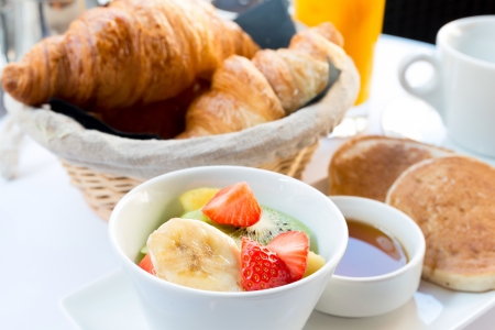 Breakfast with coffee and croissants in a basket on tableの写真素材