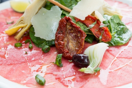 Fresh Sliced raw beef meat with leaf lettuce on tableの写真素材