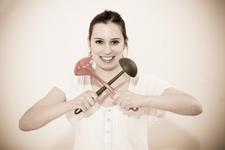 Beautiful housewife with kitchen utensils on white backgroundの写真素材
