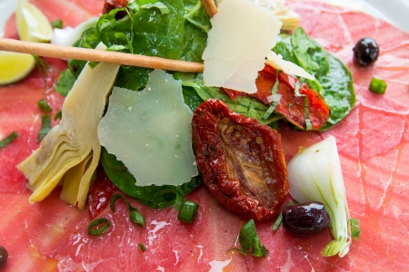 Fresh Sliced raw beef meat with leaf lettuce on tableの写真素材