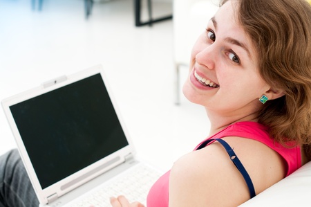 young woman sitting comfortable with laptop on couchの写真素材