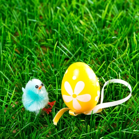 Easter eggs and chickens on green grass