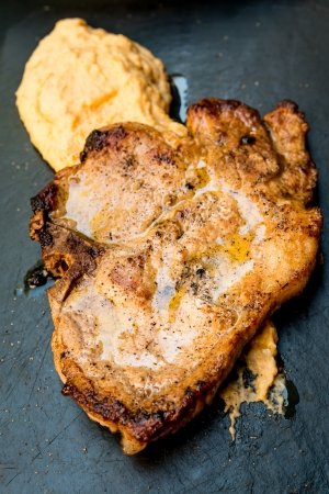 pork chop-delicious juicy pork chop with mash potatoes in black slateの写真素材
