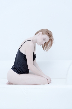 beautiful young woman in lingerie on a sofaの写真素材