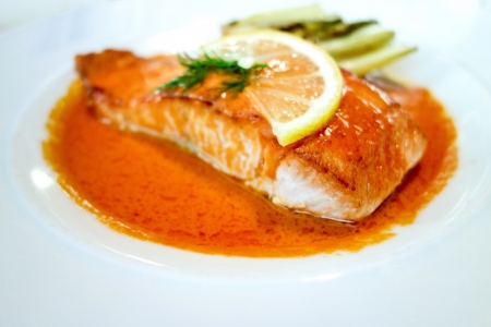 grilled salmon and lemon - french cuisine dish with tomato and salmonの写真素材