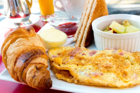 Breakfast with orange juice and omelet in a basket on tableの写真素材