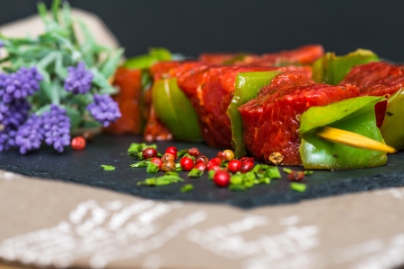 tasty meat and vegetables skewers on a slate plate の写真素材