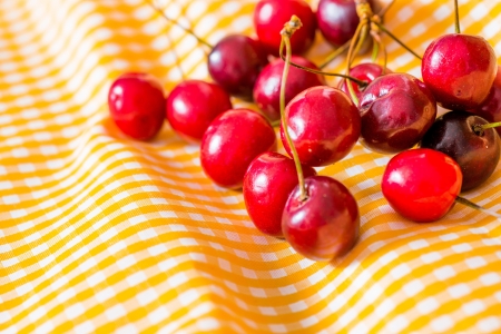 fresh cherries on yellow napkinの写真素材