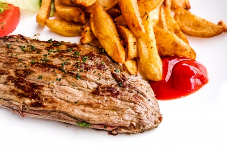 juicy steak beef meat with tomato and french fries の写真素材