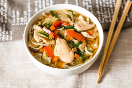 Bowls of Asian soup noodles and vegetables with Chopstick 