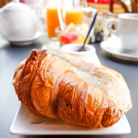 Breakfast with coffee and croissants on tableの写真素材