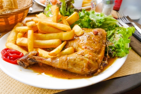 Chicken with sauce and golden French fries potatoes の写真素材