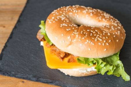 Bagel with fresh cheese and fresh lettuce on napkinの写真素材